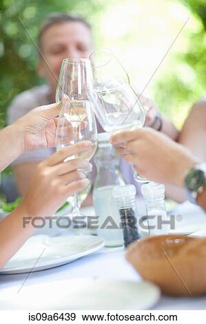 Stock Photo - Family toasting each other at table. Fotosearch