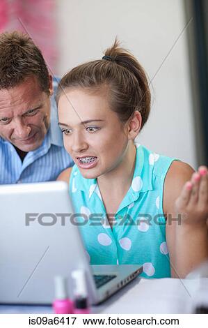 Stock Photo - Father and daughter using laptop. Fotosearch
