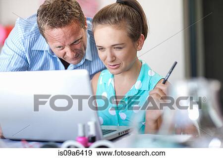 Stock Photo - Father and daughter using laptop. Fotosearch