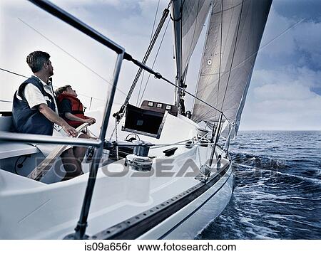 Father and son steering boat on water View Large Photo Image Stock Photography - Father and son steering boat on water. Fotosearch