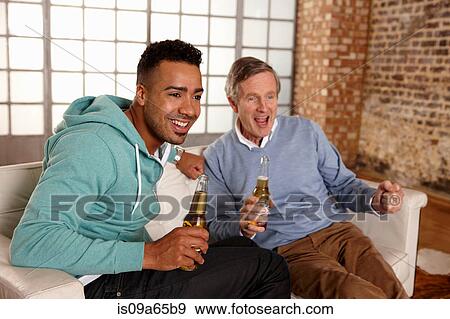 Stock Photo - Father and son watching sports together. Fotosearch