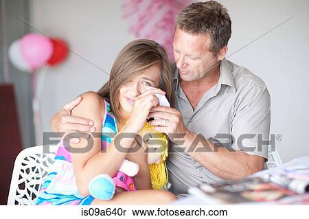 Stock Photography - Father comforting teenage daughter. Fotosearch