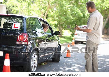 Stock Photograph - Father teaching teenage daughter driving. Fotosearch