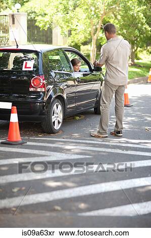 Stock Photography - Father teaching teenage daughter driving. Fotosearch