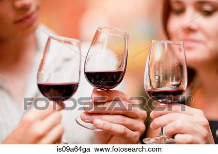 Stock Image - Friends tasting wine in grocery. Fotosearch
