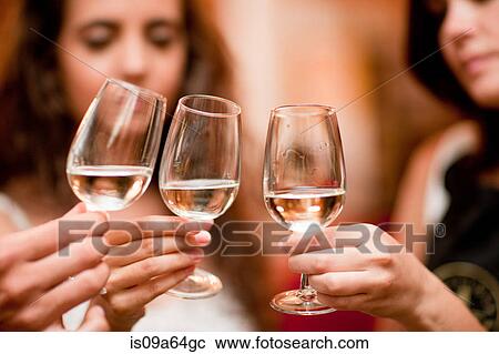 Stock Image - Friends tasting wine in grocery. Fotosearch