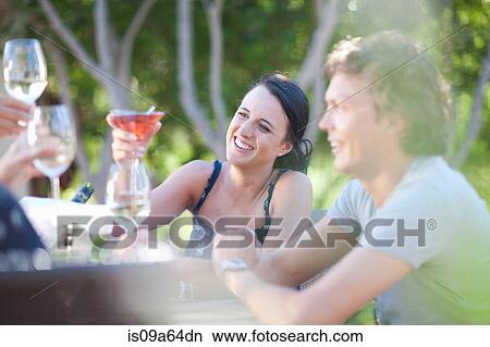 Friends toasting each other outdoors View Large Photo Image Picture - Friends toasting each other outdoors. Fotosearch