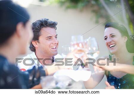 Friends toasting each other outdoors View Large Photo Image Picture - Friends toasting each other outdoors. Fotosearch