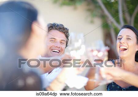 Stock Photography - Friends toasting each other outdoors. Fotosearch