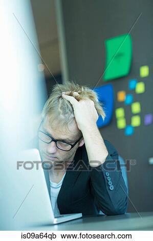Stock Image - Frustrated businessman using laptop. Fotosearch