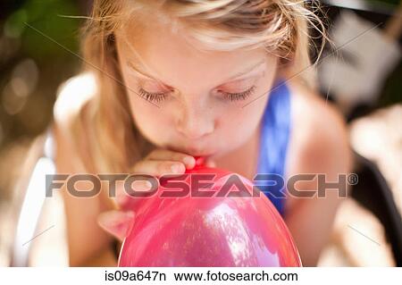 Girl blowing up balloon at party View Large Photo Image Picture - Girl blowing up balloon at party. Fotosearch