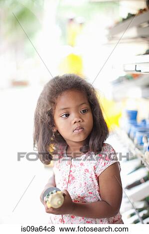 Stock Photo - Girl carrying toy outdoors. Fotosearch