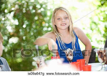 Girl having ice cream sundae at party View Large Photo Image Stock Image - Girl having ice cream sundae at party. Fotosearch