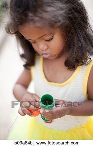 Stock Image - Girl holding bubble soap container. Fotosearch