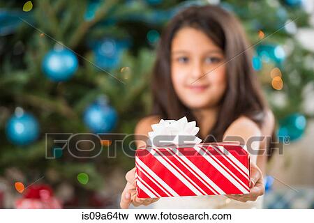 Stock Photo - Girl holding Christmas present. Fotosearch