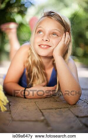 Stock Photo - Girl laying on ground outdoors. Fotosearch