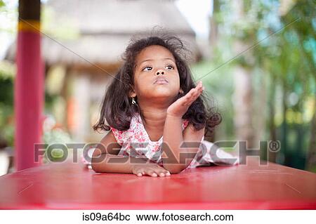Stock Image - Girl laying on picnic table. Fotosearch