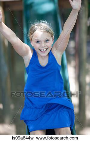 Stock Photo - Girl playing on slide outdoors. Fotosearch
