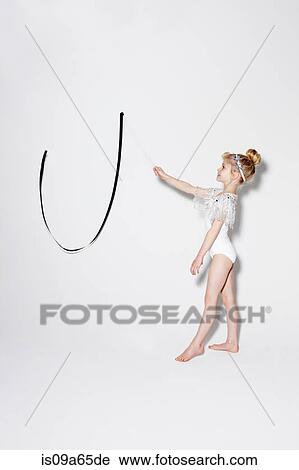 Stock Image - Girl playing with ribbon streamers. Fotosearch