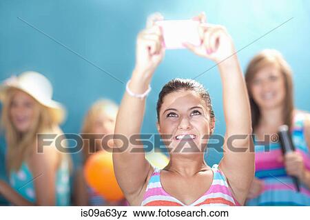Stock Photo - Girl taking picture with cell phone. Fotosearch