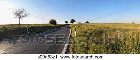 Stock Image - Grassy fields and rural road. Fotosearch