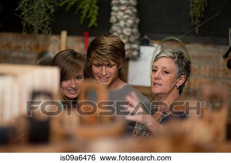 Stock Photograph - Grocer helping couple in grocery store. Fotosearch
