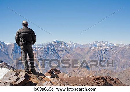 Hiker overlooking snowy mountains View Large Photo Image Stock Image - Hiker overlooking snowy mountains. Fotosearch