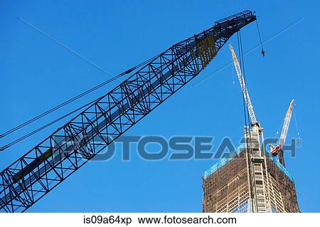 Low angle view of crane and skyscraper View Large Photo Image Stock Photography - Low angle view of crane and skyscraper. Fotosearch