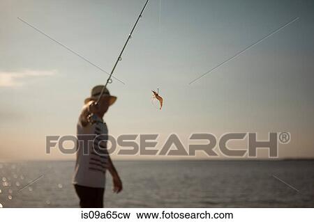Stock Photo - Man displaying lure on fishing line. Fotosearch