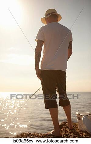 Man fishing in still ocean View Large Photo Image Stock Photo - Man fishing in still ocean. Fotosearch