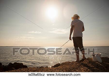 Man fishing in still ocean View Large Photo Image Stock Photo - Man fishing in still ocean. Fotosearch
