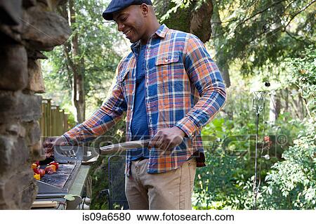Man grilling kebabs outdoors View Large Photo Image Stock Image - Man grilling kebabs outdoors. Fotosearch