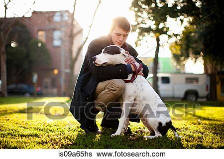 Man hugging dog in park View Large Photo Image Stock Photograph - Man hugging dog in park. Fotosearch