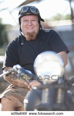 Stock Photo - Man in vintage goggles on motorcycle. Fotosearch