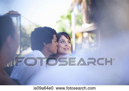 Man kissing girlfriend at table outdoors View Large Photo Image Stock Image - Man kissing girlfriend at table outdoors. Fotosearch