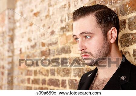 Picture - Man leaning on brick wall. Fotosearch