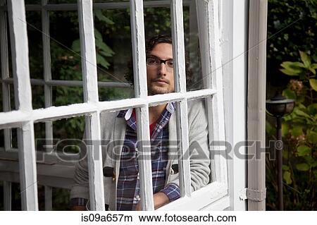 Picture - Man looking out window. Fotosearch