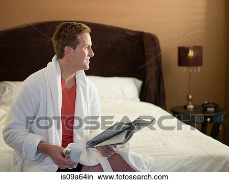 Man reading newspaper on bed View Large Photo Image Picture - Man reading newspaper on bed. Fotosearch