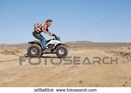 Man riding four-wheeler in desert View Large Photo Image Stock Image - Man riding four-wheeler in desert. Fotosearch