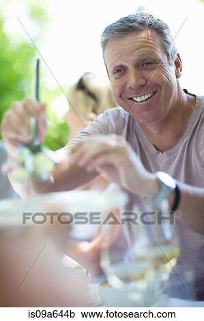 Man serving salad at table outdoors View Large Photo Image Stock Image - Man serving salad at table outdoors. Fotosearch