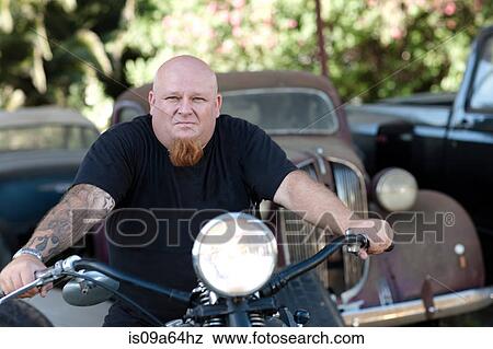 Stock Photo - Man sitting on motorcycle. Fotosearch
