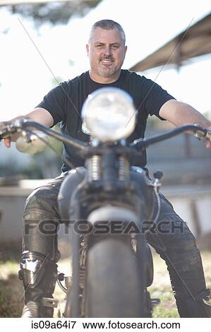 Stock Photo - Man sitting on motorcycle. Fotosearch