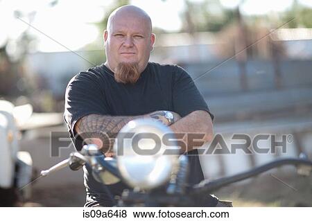 Stock Photo - Man sitting on motorcycle. Fotosearch