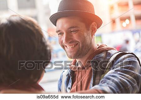 Stock Image - Man smiling at girlfriend outdoors. Fotosearch