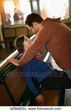 Stock Photo - Man standing over girlfriend on ferry. Fotosearch