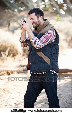 Stock Photography - Man taking picture outdoors. Fotosearch