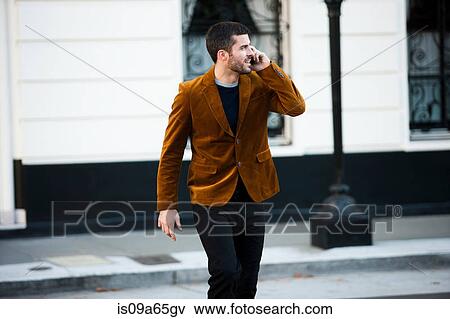 Stock Photo - Man talking on cell phone on city street. Fotosearch