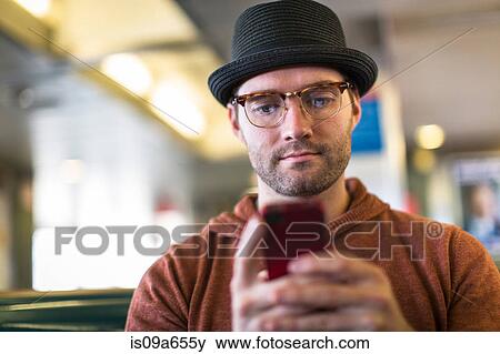 Stock Photo - Man using cell phone on bench. Fotosearch