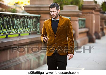 Man using cell phone on city street View Large Photo Image Stock Photograph - Man using cell phone on city street. Fotosearch