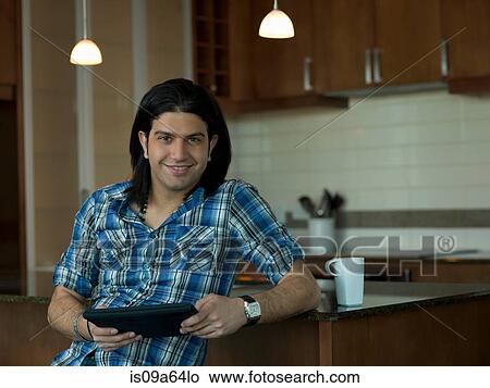 Picture - Man using tablet computer at counter. Fotosearch